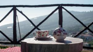 een theepot en een kopje op een tafel bij Casa dos Avos in Calheta