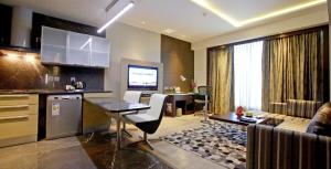 a kitchen and living room with a table and a couch at Crowne Plaza Greater Noida, an IHG Hotel in Greater Noida