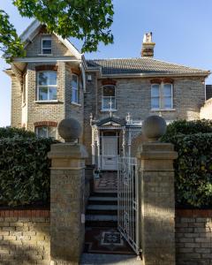 une maison en briques avec un portail et une clôture dans l'établissement Cranborne House, à Poole