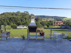 einen großen Kamin auf einer Terrasse mit einem Tisch und Stühlen in der Unterkunft EL CINCHO - LA COLINA in Arnuero