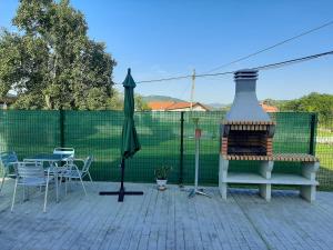 eine Terrasse mit einem Kamin, einem Tisch und Stühlen in der Unterkunft EL CINCHO - LA COLINA in Arnuero