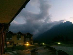 Blick auf ein Haus in der Nacht mit einem Berg in der Unterkunft APPARTAMENTO AL Sasso in Andalo