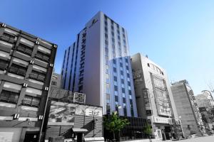 un grand bâtiment au milieu d'une ville dans l'établissement Quintessa Hotel Sapporo Susukino, à Sapporo