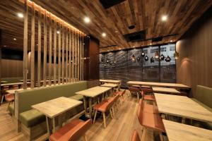 un restaurant avec des tables et des chaises en bois et une fenêtre dans l'établissement Quintessa Hotel Sapporo Susukino, à Sapporo