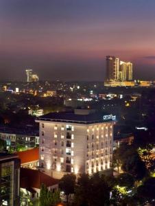 un bâtiment éclairé dans une ville la nuit dans l'établissement Amaris Hotel Darmo Surabaya, à Surabaya