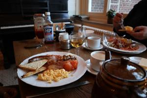 een tafel met een bord ontbijtproducten erop bij Talbot House in Poperinge