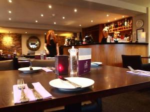 - une table avec des assiettes et des ustensiles dans un restaurant dans l'établissement Inchture Hotel, à Dundee