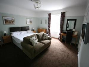 - une chambre avec un lit, un canapé et une télévision dans l'établissement Inchture Hotel, à Dundee