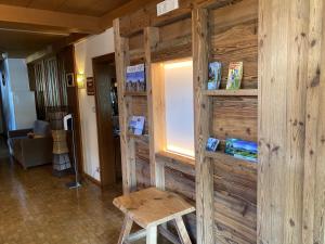 a room with a wooden wall with a table and a stool at Hotel Garni Savoy in Castelrotto