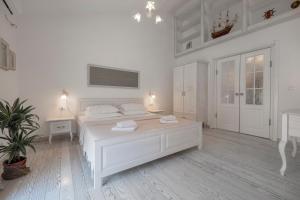 um quarto branco com uma cama branca e uma mesa em Marinero Apartments em Budva