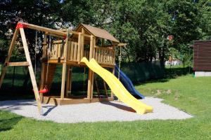 un parque infantil de madera con un tobogán en el césped en Vila ELIS, en Jeseník