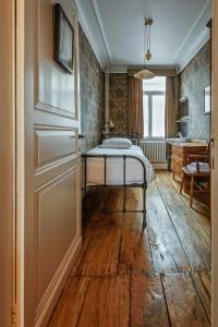 een slaapkamer met een bed, een bureau en een deur bij Talbot House in Poperinge