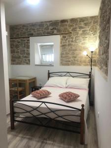 una camera con un letto con due cuscini sopra di Rooms and Apartments Emily a Spalato (Split)