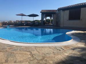 una piscina in un cortile accanto a una casa di Villa Peonia a Budoni