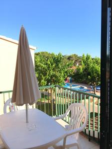 un parasol blanc assis sur une table sur un balcon dans l'établissement Apartamentos Surest, à Cala en Blanes