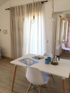 - une table et des chaises blanches dans une chambre avec fenêtre dans l'établissement Apartamentos Surest, à Cala en Blanes