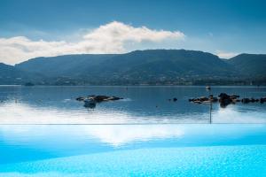 un grande bacino d'acqua con montagne sullo sfondo di Hotel Shegara a Porto Vecchio