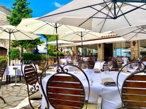 einen Tisch mit Stühlen und Sonnenschirmen in einem Restaurant in der Unterkunft Auberge du Vieux Château in Cabris