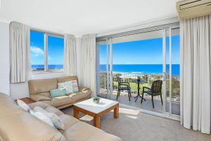 sala de estar con sofá y vistas al océano en Elouera Tower, en Maroochydore