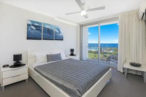 1 dormitorio con cama y ventana grande en Elouera Tower, en Maroochydore