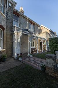 une grande maison en briques avec un jardin en face de celle-ci dans l'établissement Cranborne House, à Poole