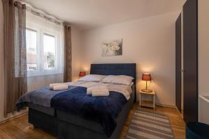 een slaapkamer met een blauw bed en handdoeken bij Villa Relax Home Sun in Umag