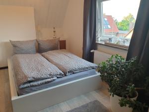 Cama en habitación pequeña con ventana en Ferienwohnung Möwenblick, en Flensburg