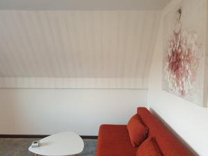 una sala de estar con un sofá rojo y una pintura en Ferienwohnung Möwenblick, en Flensburg