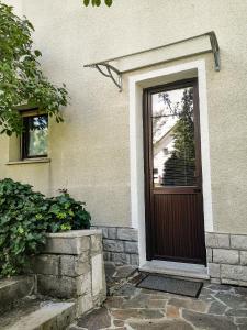 eine braune Tür eines Hauses mit Fenster in der Unterkunft Apartment & rooms Grmek in Postojna