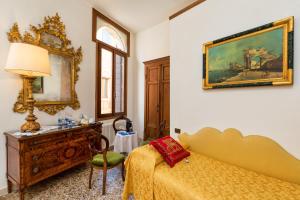 sypialnia z łóżkiem, biurkiem i lustrem w obiekcie Luxury Venetian Rooms w Wenecji