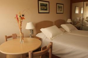 - une chambre avec un lit et une table ornée d'un vase de fleurs dans l'établissement Salto Grande Hotel, à Punta del Este