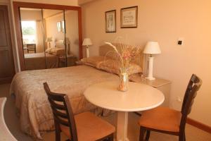 - une chambre avec un lit, une table et des chaises dans l'établissement Salto Grande Hotel, à Punta del Este