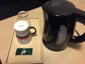 a coffee maker and a cup on a table at Hotel Route Inn Kesennuma Chuo Inter in Kesennuma