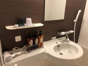 a bathroom with a sink and a toilet and a mirror at Hotel Route Inn Kesennuma Chuo Inter in Kesennuma