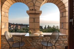 - une terrasse avec 2 chaises et une table avec un livre dans l'établissement Kalamitsi Hotel, à Kardamyli