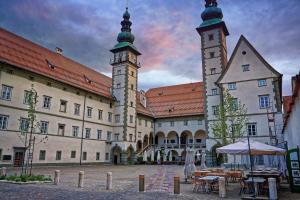 un grande edificio con due torri con orologio di Jugend- und Familiengästehaus Klagenfurt a Klagenfurt