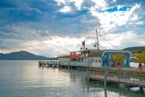 una barca è ormeggiata in un molo sull'acqua di Jugend- und Familiengästehaus Klagenfurt a Klagenfurt