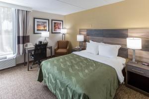 um quarto de hotel com uma cama grande e uma secretária em Quality Inn & Suites em Plattsburgh