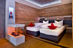 2 camas en una habitación con chimenea en PETE Alpine Boutique Hotel - klein und fein - Private SPA Suiten und Zimmer, en Sankt Anton am Arlberg