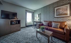 a living room with a couch and a tv at Monte Carlo Inn Markham in Markham