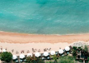 a group of people on a beach with umbrellas at Meliá Bali in Nusa Dua