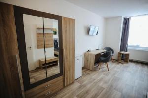 Cette chambre comprend un miroir, un bureau et une chaise. dans l'établissement Second Home Hotel, à Merseburg