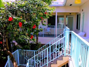 une maison avec une balustrade bleue et un arbre avec des fleurs rouges dans l'établissement Villa Venezia, à Fort Lauderdale