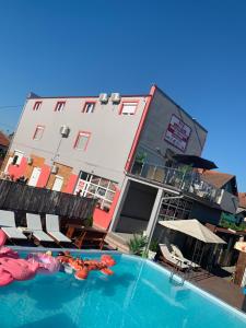 ein Hotel mit einem Pool vor einem Gebäude in der Unterkunft Apartments Vila Brzi & Beka in Šabac