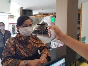 una mujer con máscara facial sosteniendo un secador de pelo en Hotel 88 Mangga Besar 62 Lokasari By WH, en Yakarta