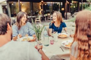 Un gruppo di persone seduti intorno a un tavolo che mangiano di Hotel Raffl a Bolzano