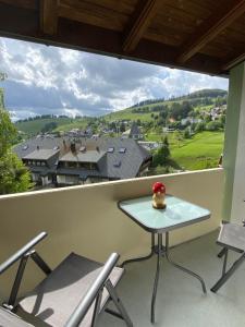 una mesa y sillas en un balcón con vistas en Herzstück, en Todtnauberg