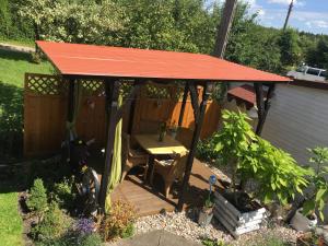 een tuinhuisje met een tafel in de tuin bij Pokoje i domki nad Kanałem Bystrym in Augustów