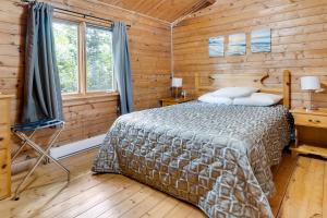 een slaapkamer met een bed in een houten hut bij Ingonish Chalets in Ingonish Beach