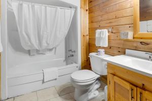 een badkamer met een toilet, een douche en een wastafel bij Ingonish Chalets in Ingonish Beach